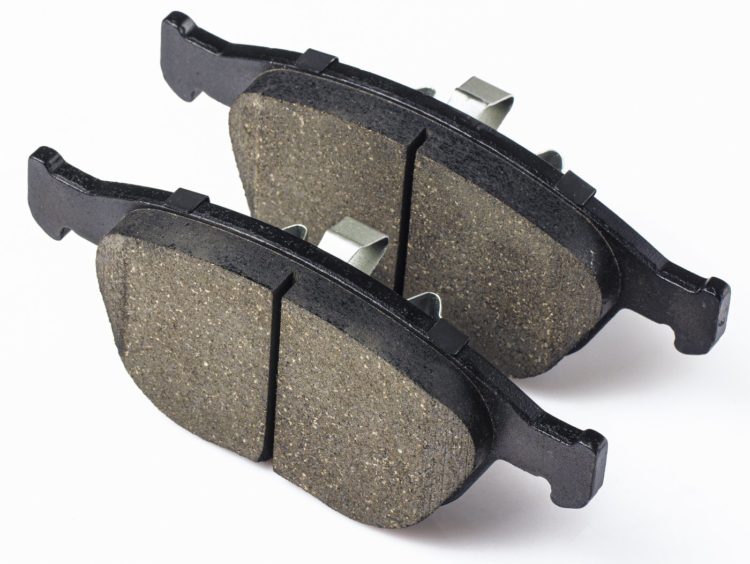 Two brake pads for disc brakes of car on a white background. Spare parts for car maintenance, brake system consumables.