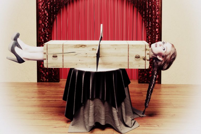 How do magicians do the sawing a person in half trick?
