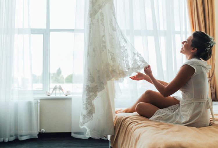 Woman looking at the lace of her wedding dress