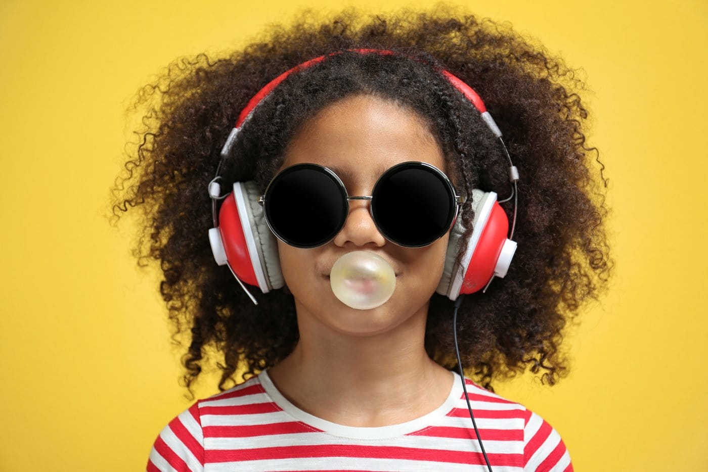 Girl with headphones blowing bubble gum